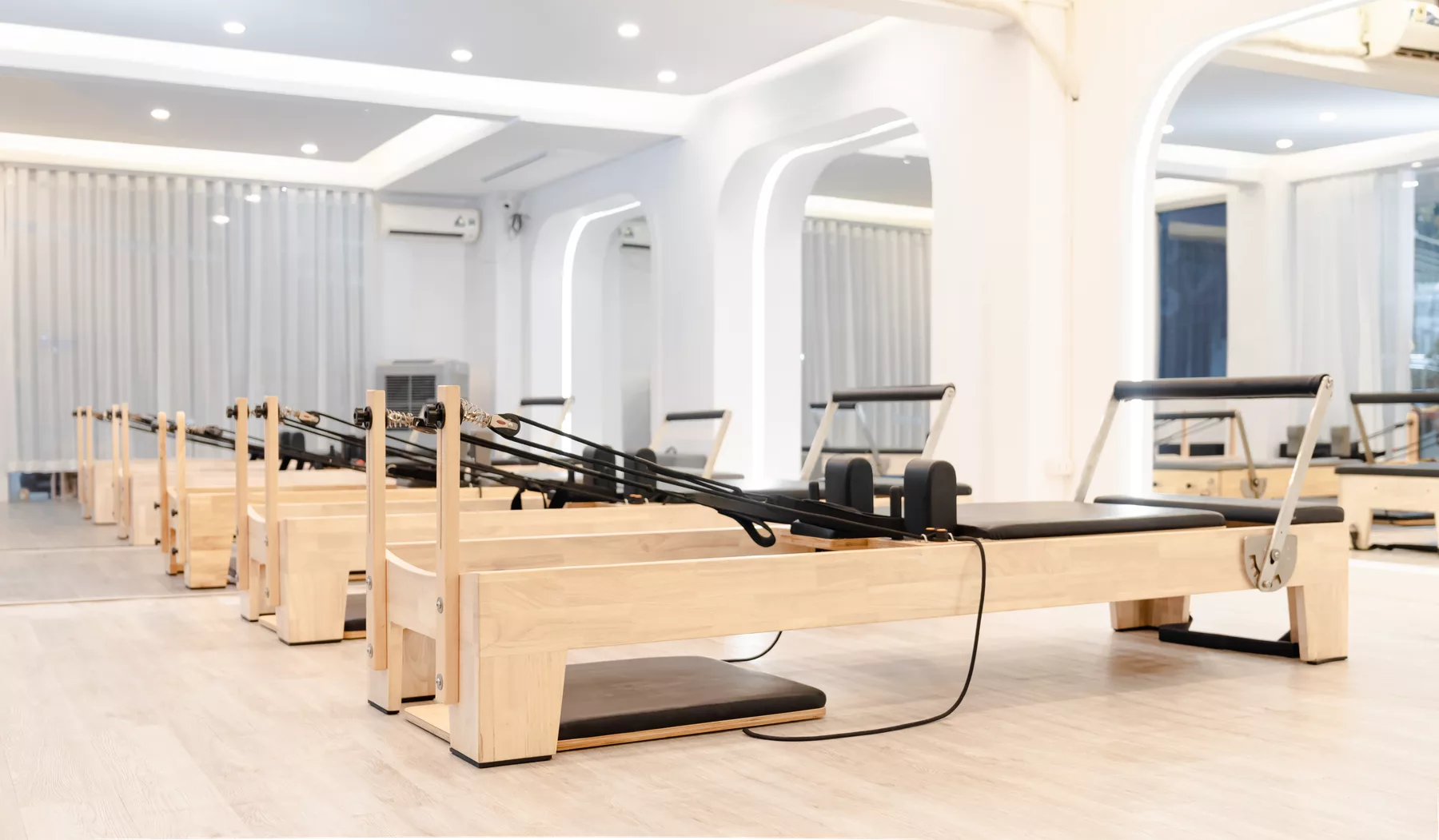 Studio de Pilates lumineux avec reformers en bois