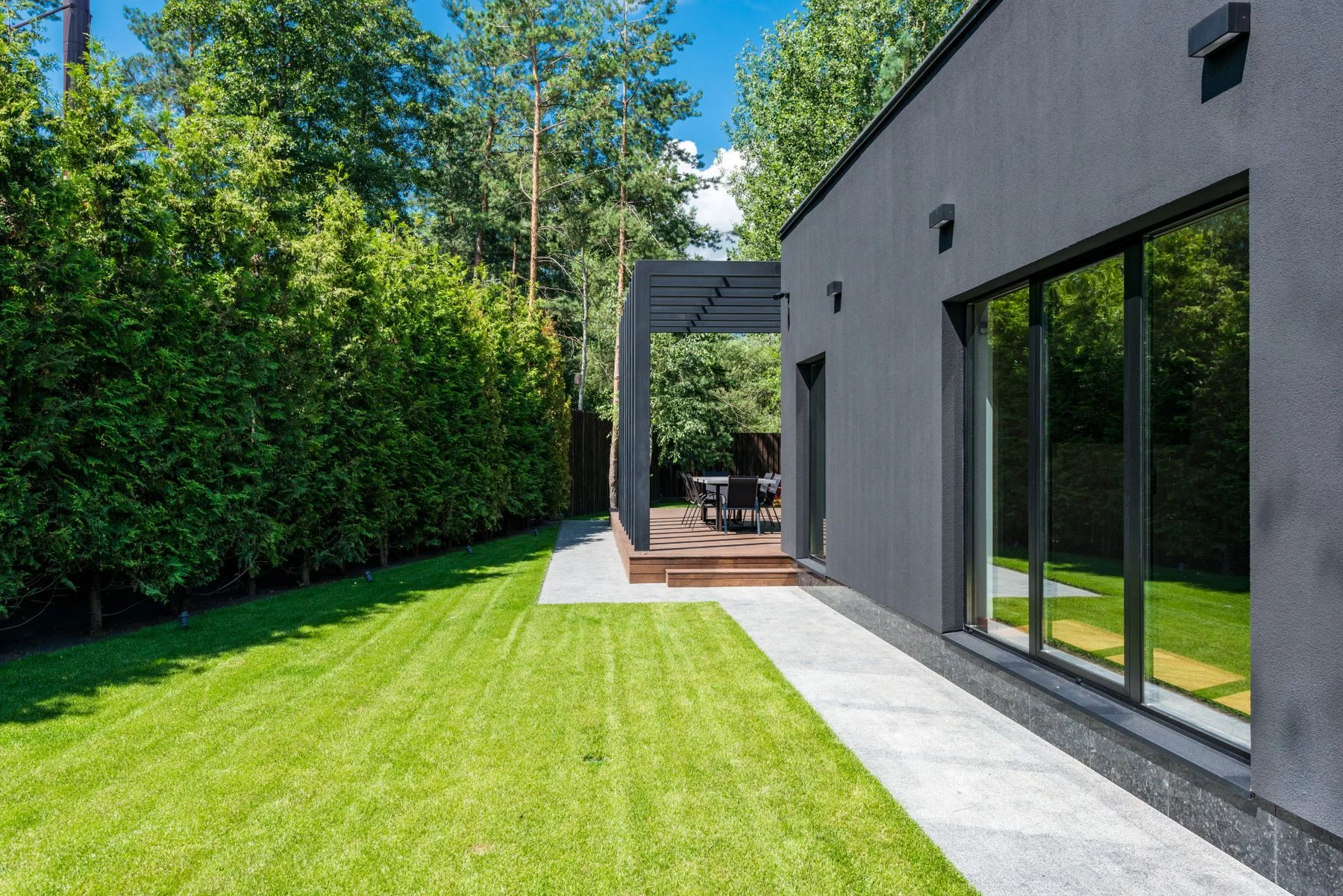 Maison moderne avec terrasse en bois et jardin